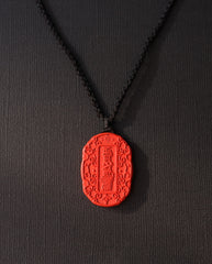 Auspicious Talisman cinnabar necklace on dark background