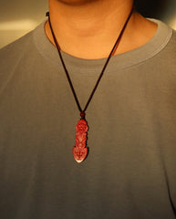 Guan Yin Phurba cinnabar necklace on dark background