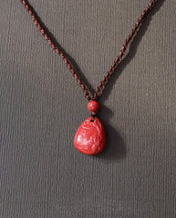 Heart Sutra Teardrop cinnabar necklace on dark background