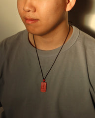 Mantra Protection Amulet cinnabar necklace on dark background