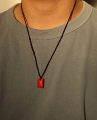 Ping An cinnabar necklace on dark background