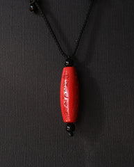 Six Character Mantra Cylinder cinnabar necklace on dark background