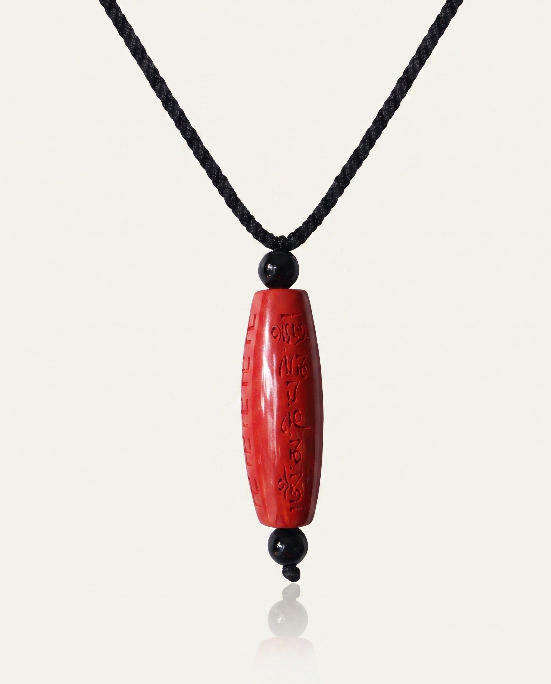 Six Character Mantra Cylinder cinnabar necklace on ivory studio background
