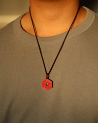 Six Character Mantra Hexagon cinnabar necklace on dark background