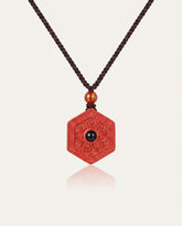 Six Character Mantra Hexagon cinnabar necklace on ivory studio background