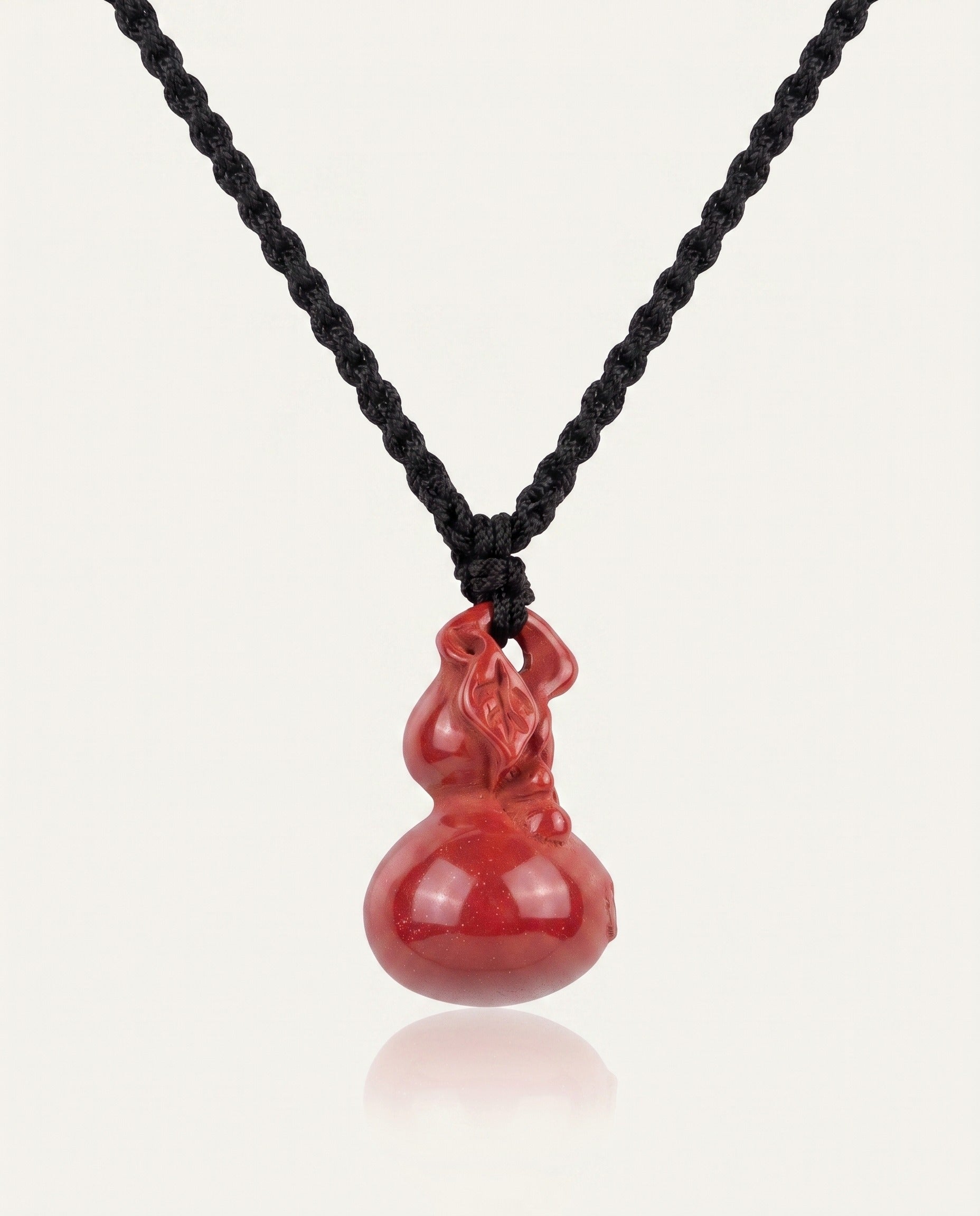 Smooth Hulu cinnabar necklace on ivory studio background