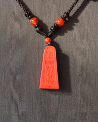 Wealth Talisman Trapezoid cinnabar necklace on dark background