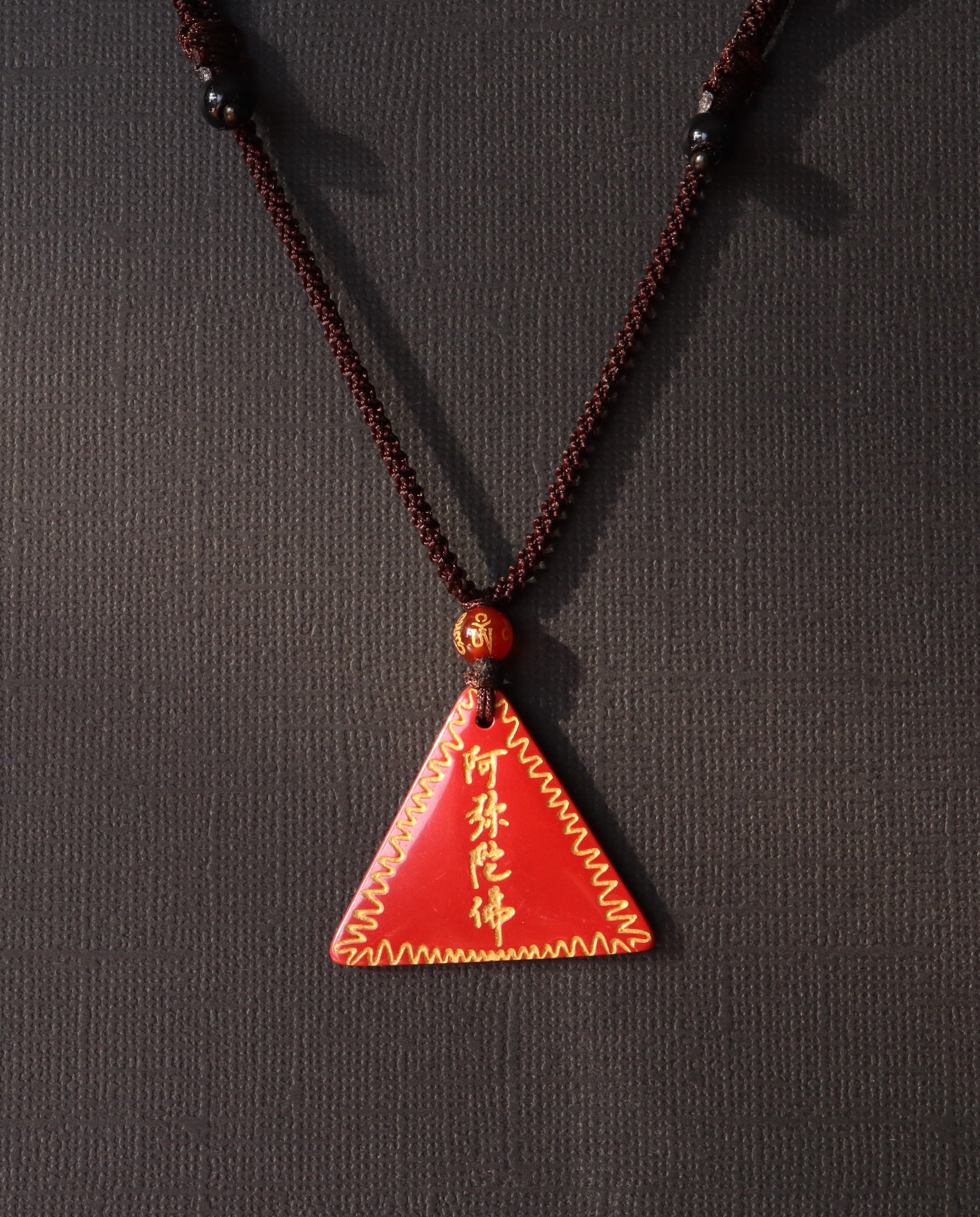 Amitabha Triangle cinnabar necklace on dark background