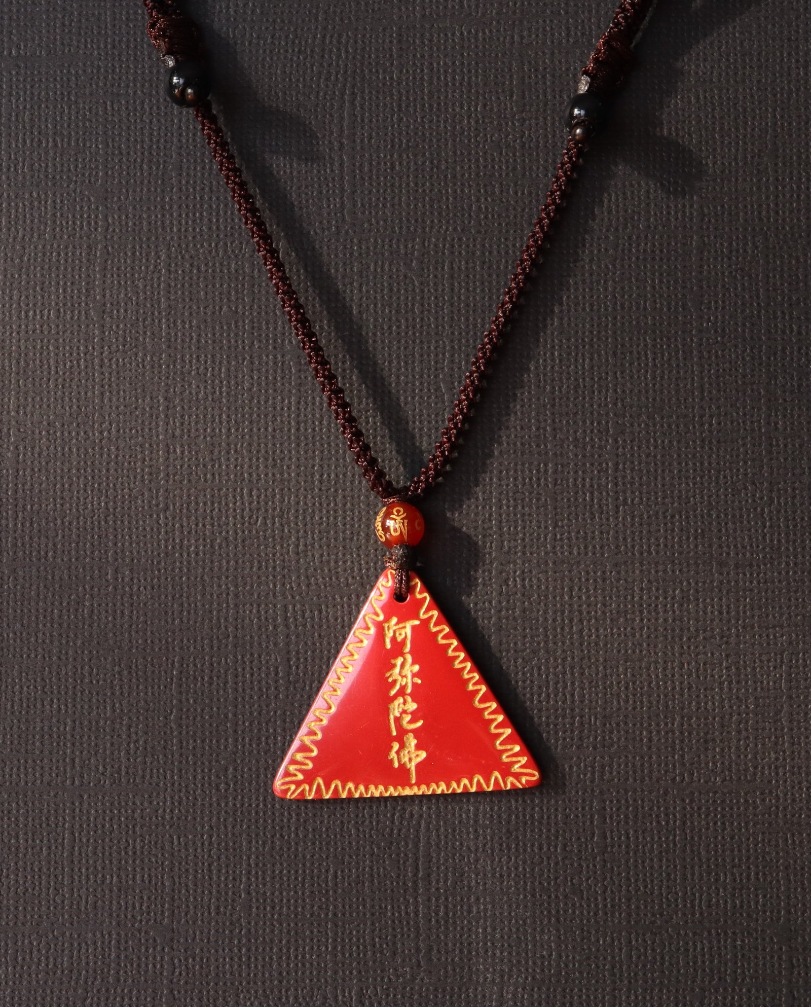 Amitabha Triangle cinnabar necklace on dark background