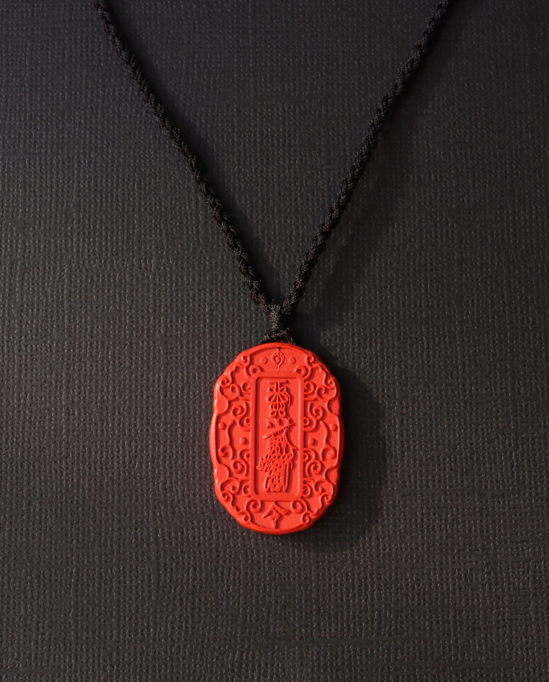 Auspicious Talisman cinnabar necklace on dark background