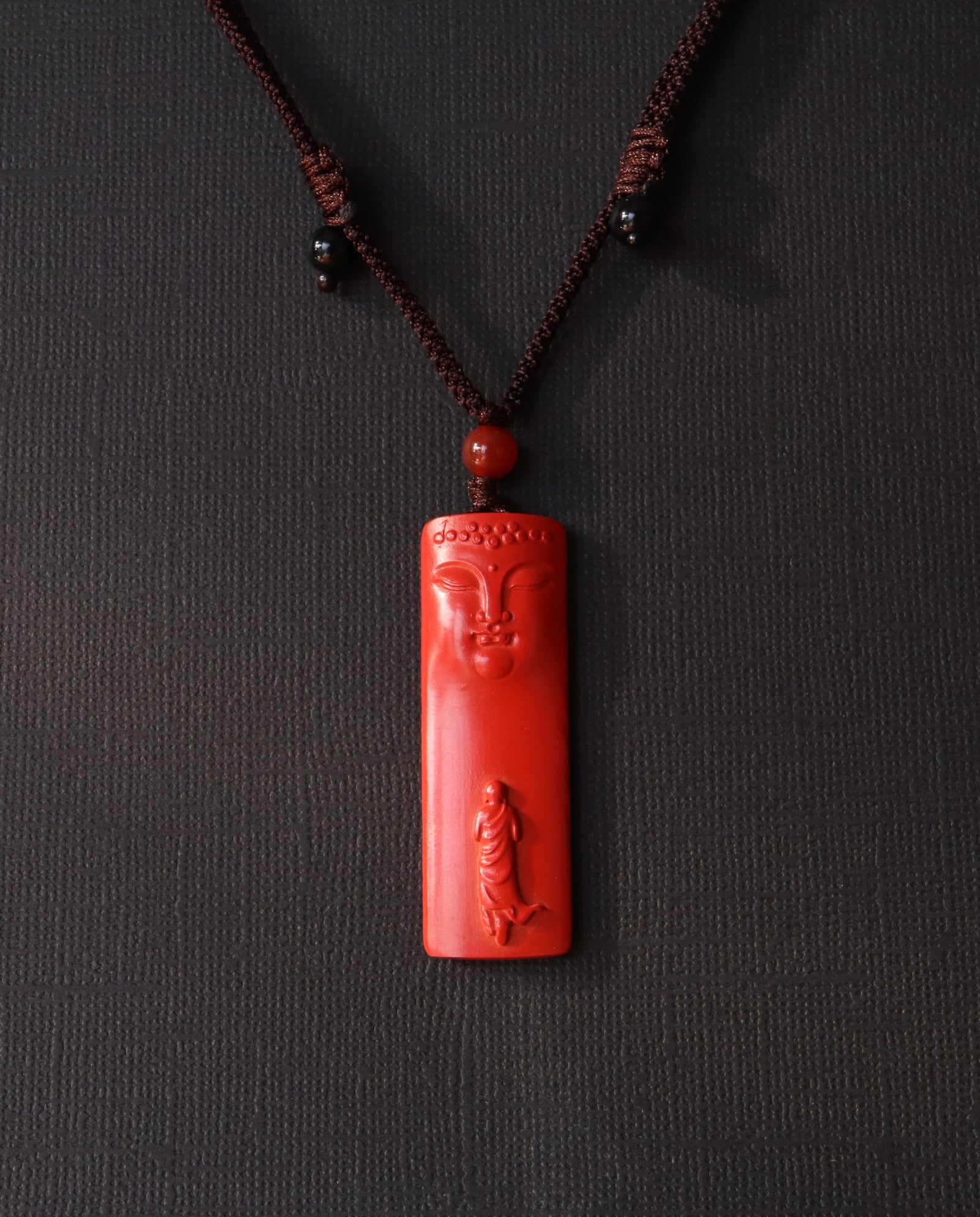 Buddha Pillar cinnabar necklace on dark background