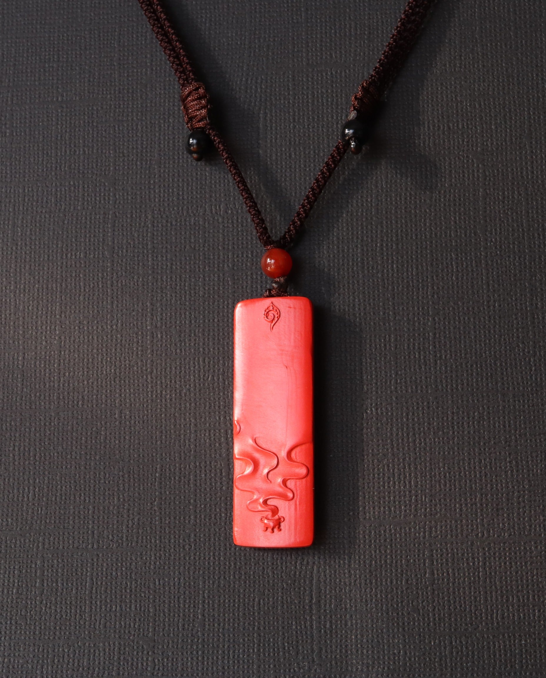 Buddha Pillar cinnabar necklace on dark background
