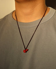 Carved Hulu cinnabar necklace on dark background