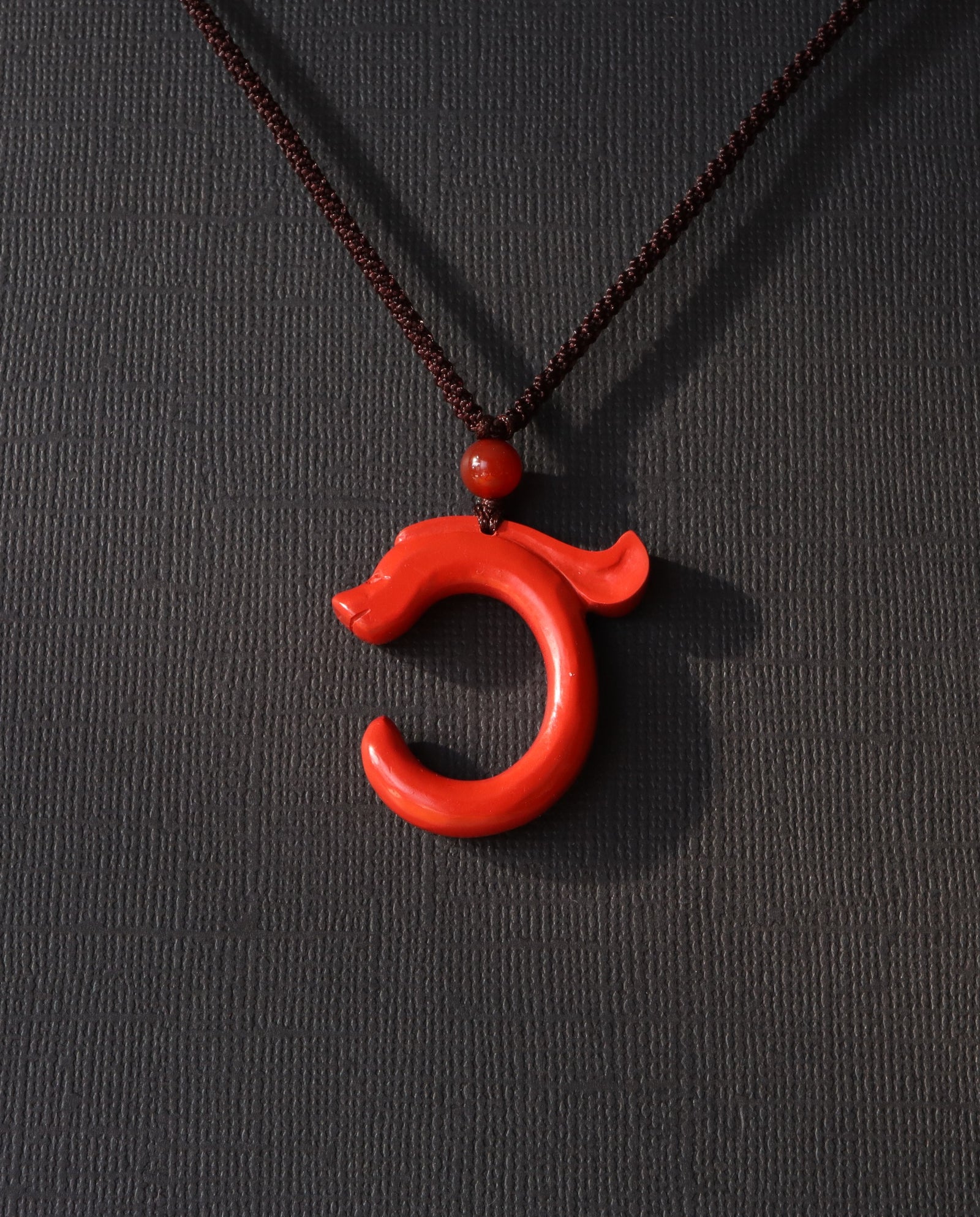 Dragon Hook cinnabar necklace on dark background