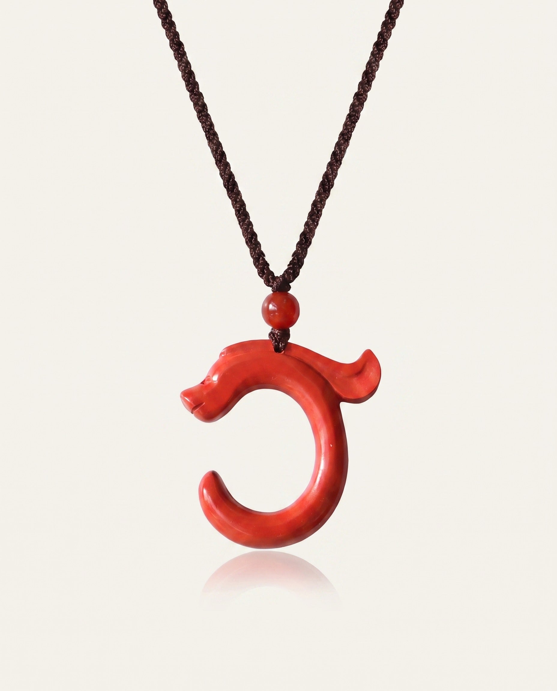 Dragon Hook cinnabar necklace on ivory studio background