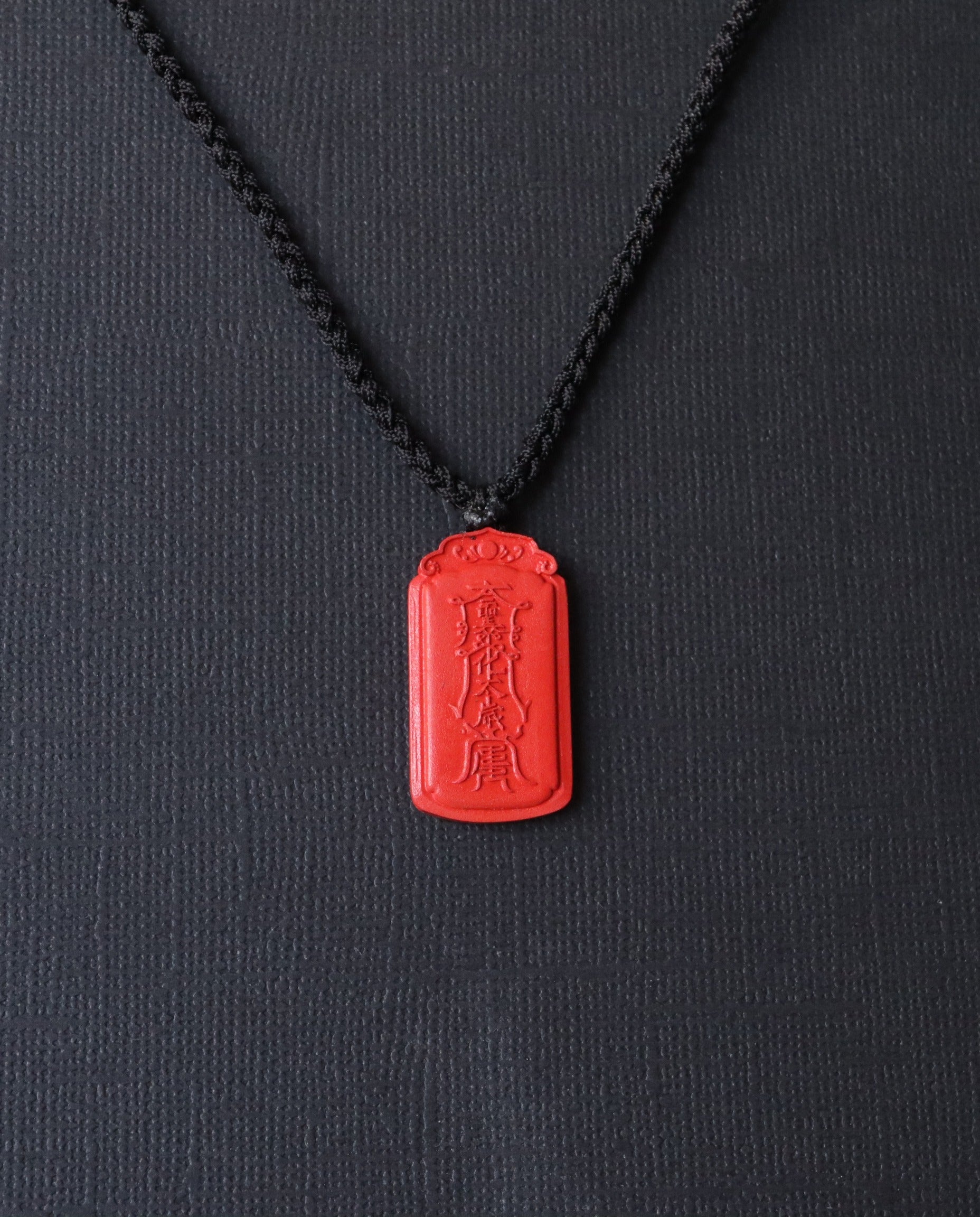 Dragon Yin Yang Talisman cinnabar necklace on dark background