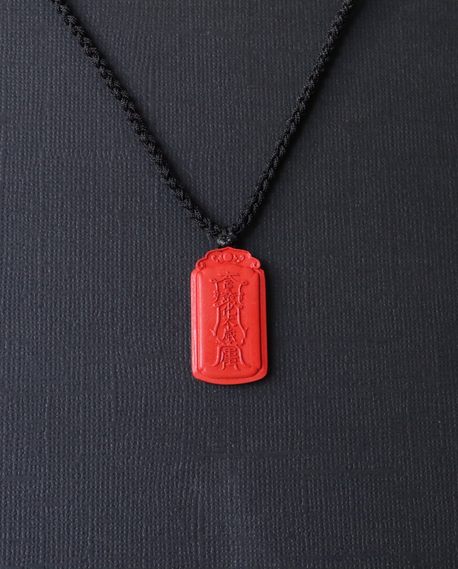 Dragon Yin Yang Talisman cinnabar necklace on dark background