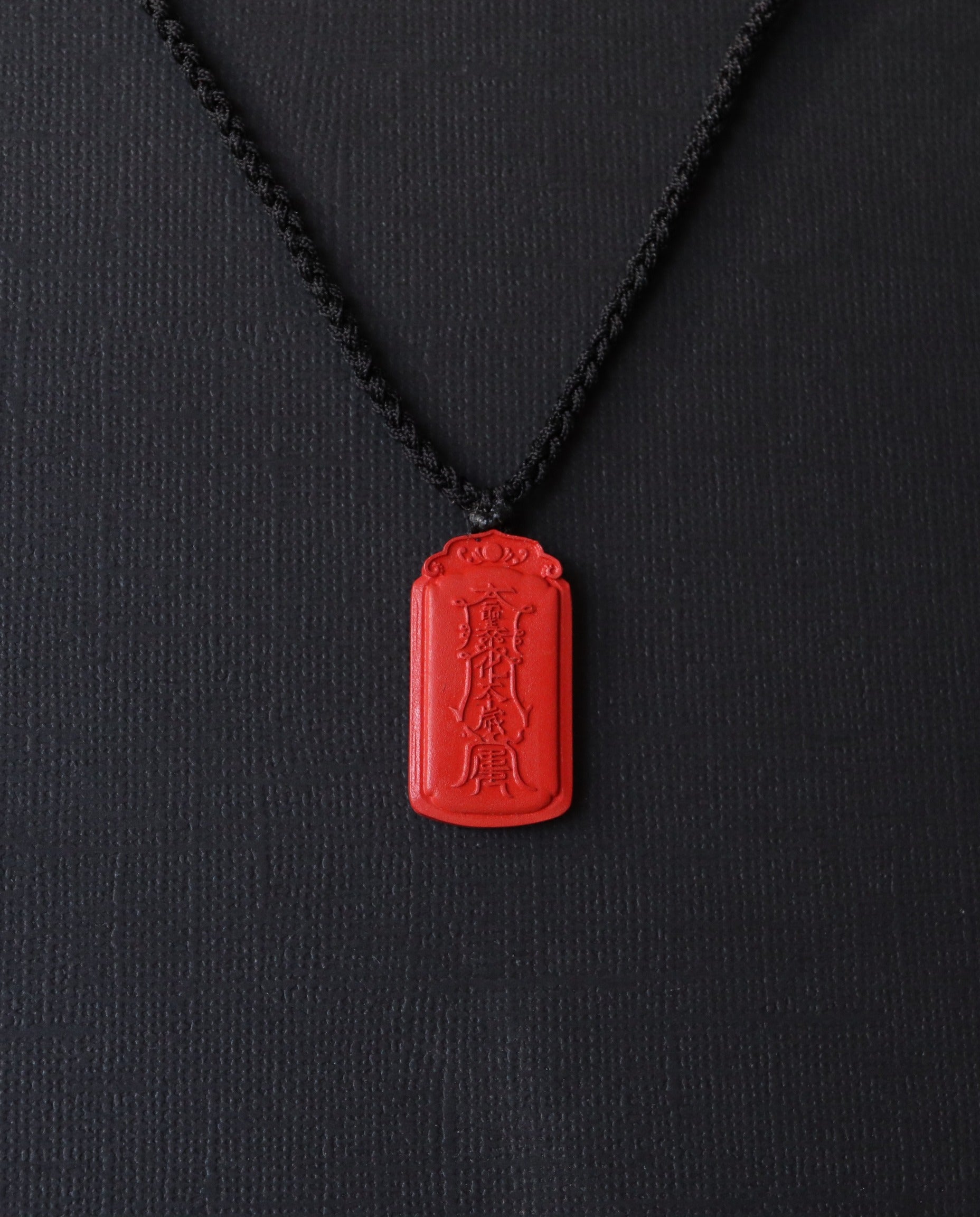 Dragon Yin Yang Talisman cinnabar necklace on dark background