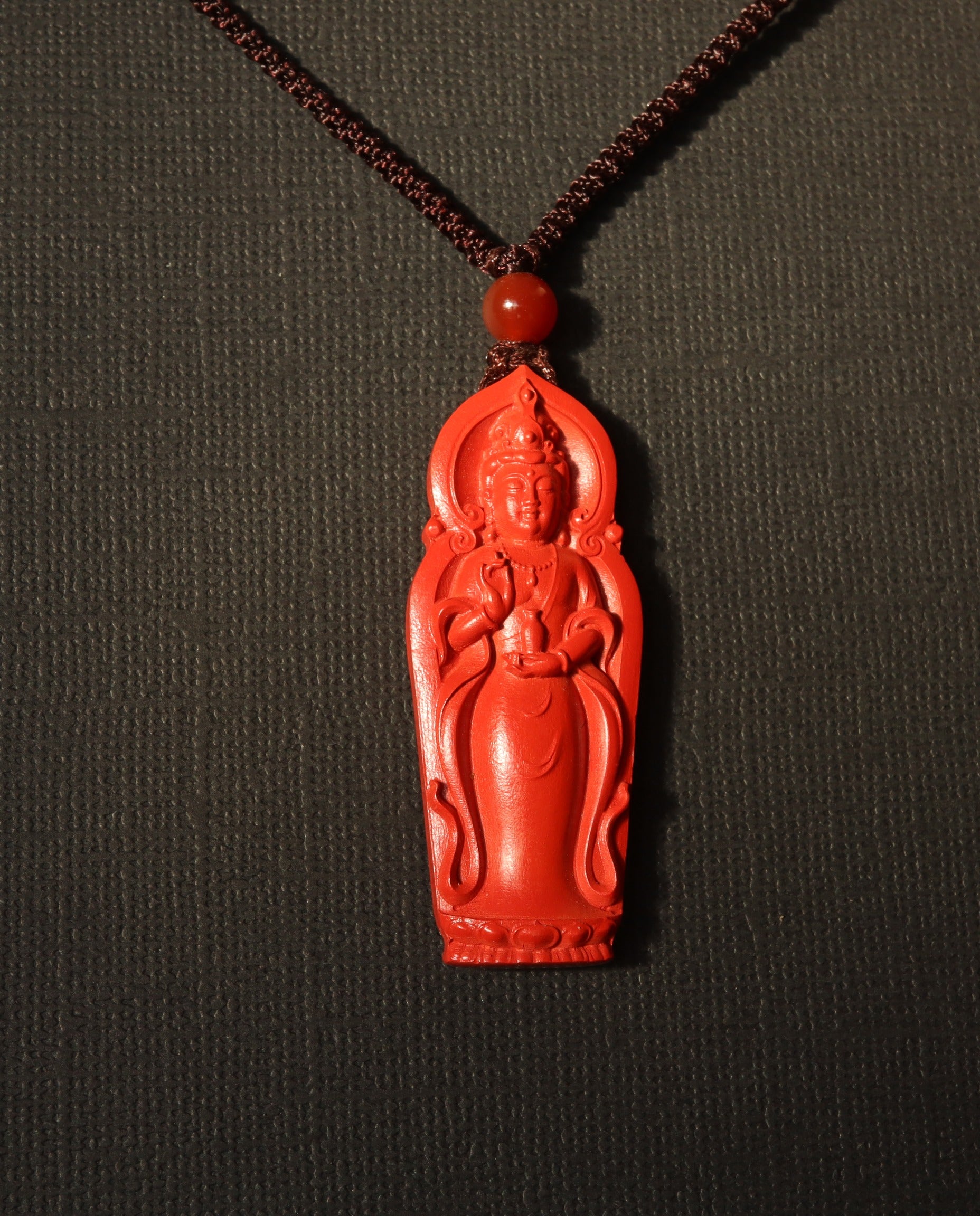 Guan Yin cinnabar necklace on dark background