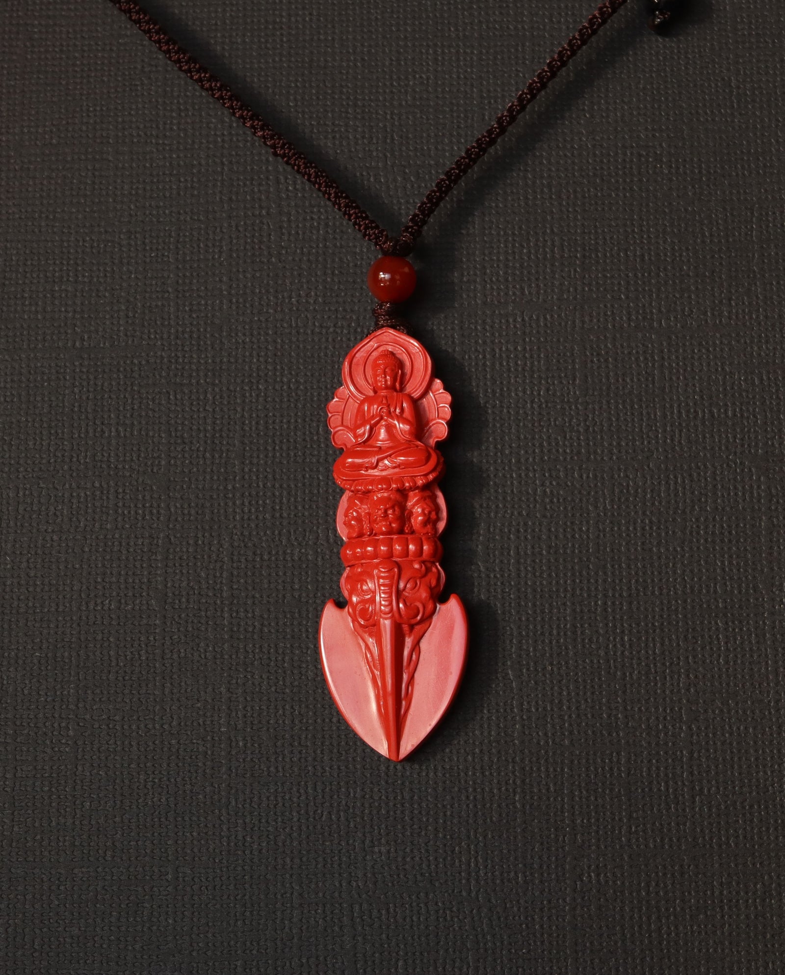 Guan Yin Phurba cinnabar necklace on dark background