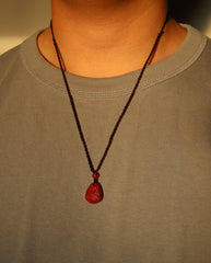 Heart Sutra Teardrop cinnabar necklace on dark background