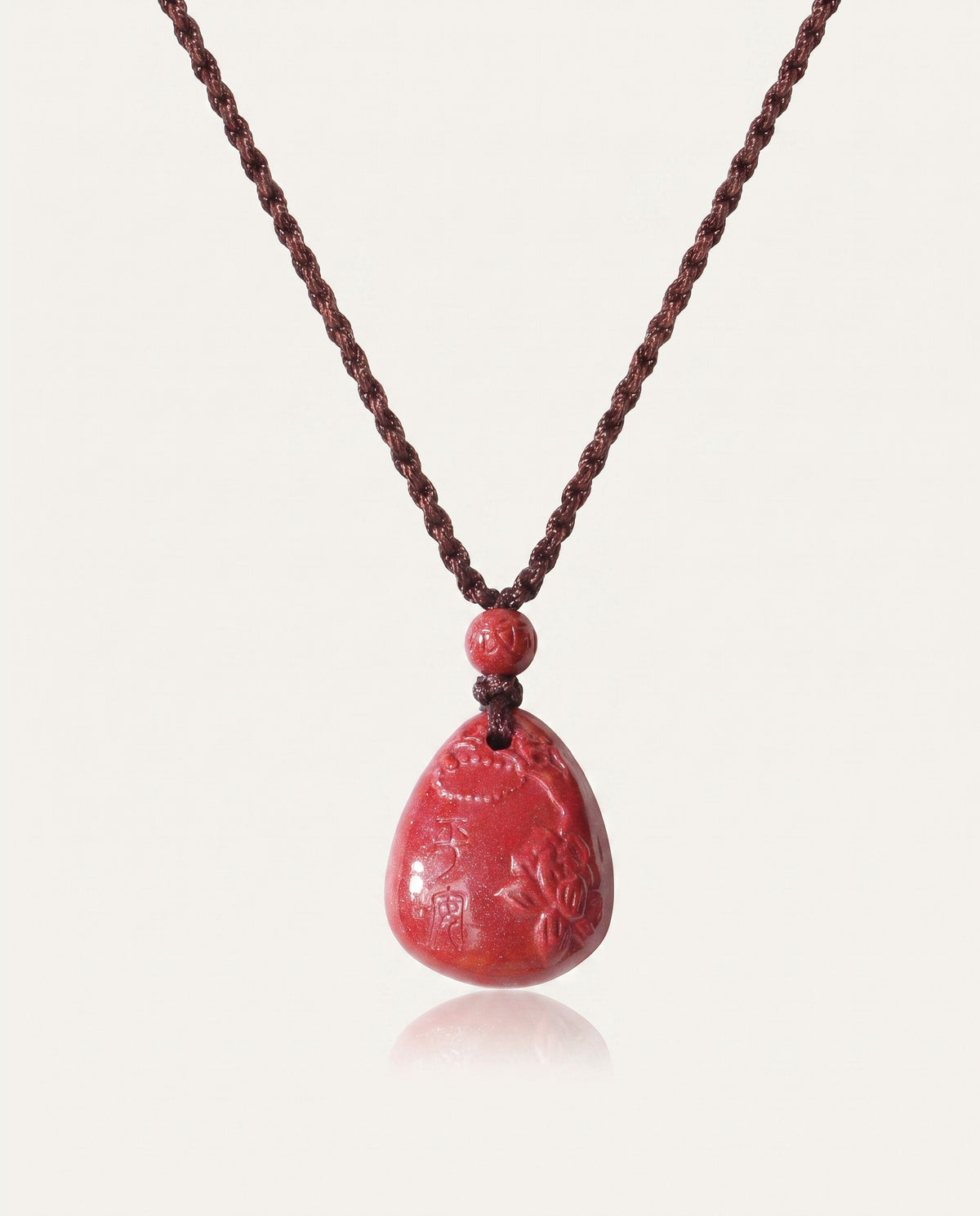 Heart Sutra Teardrop cinnabar necklace on ivory studio background
