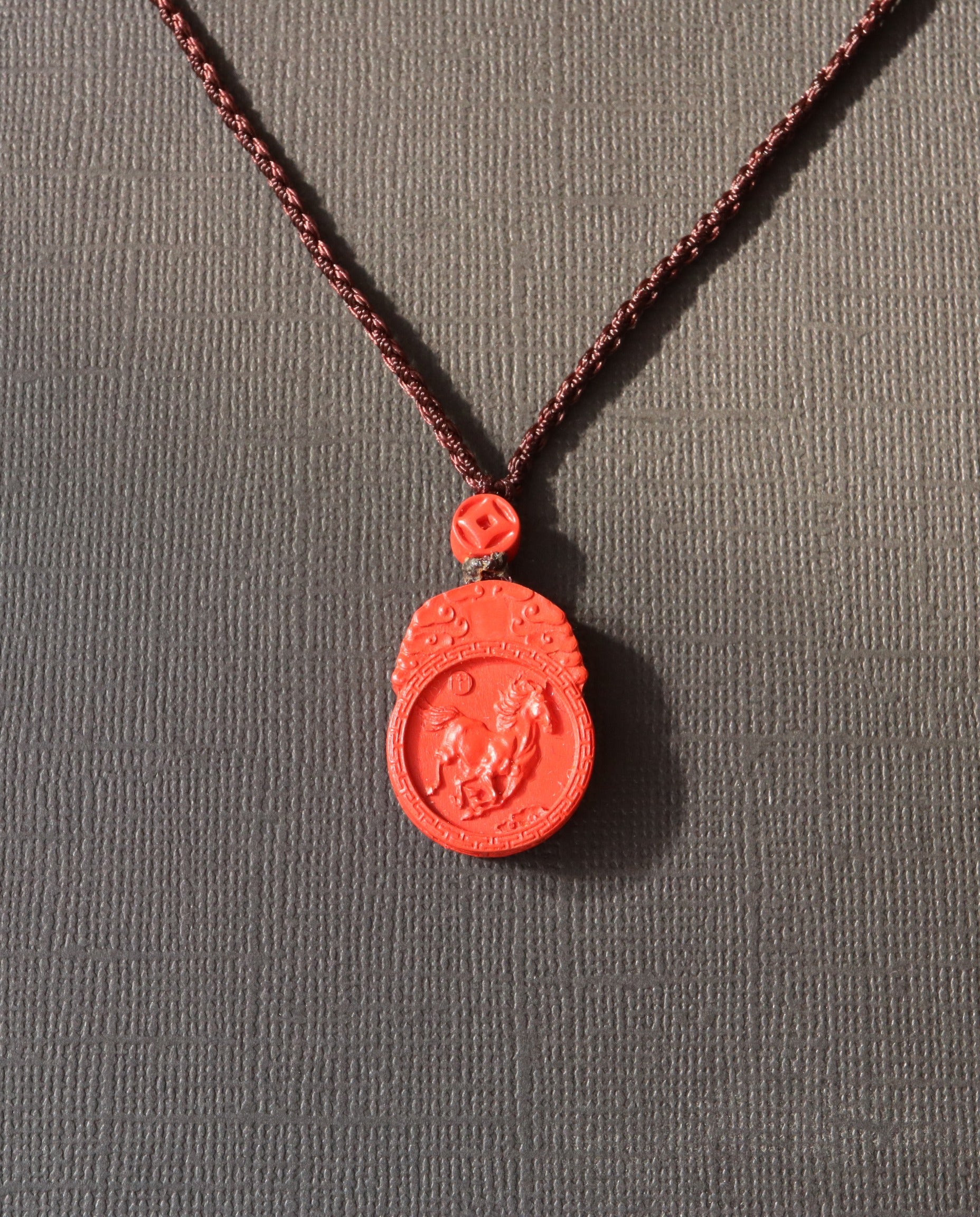Horse Guardian cinnabar necklace on dark background