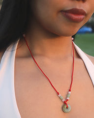 Jade pendant on red cord necklace worn