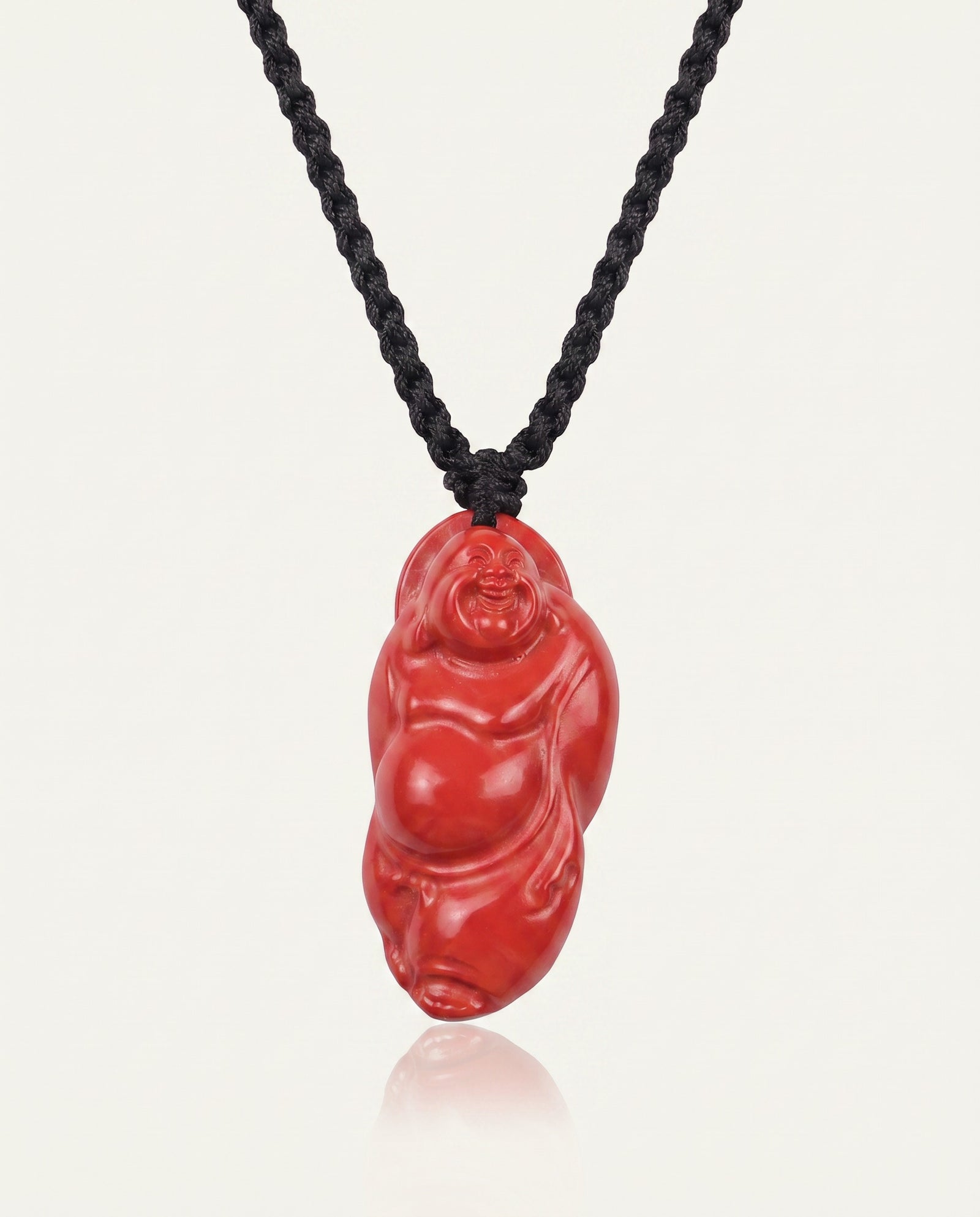 Laughing Buddha cinnabar necklace on ivory studio background