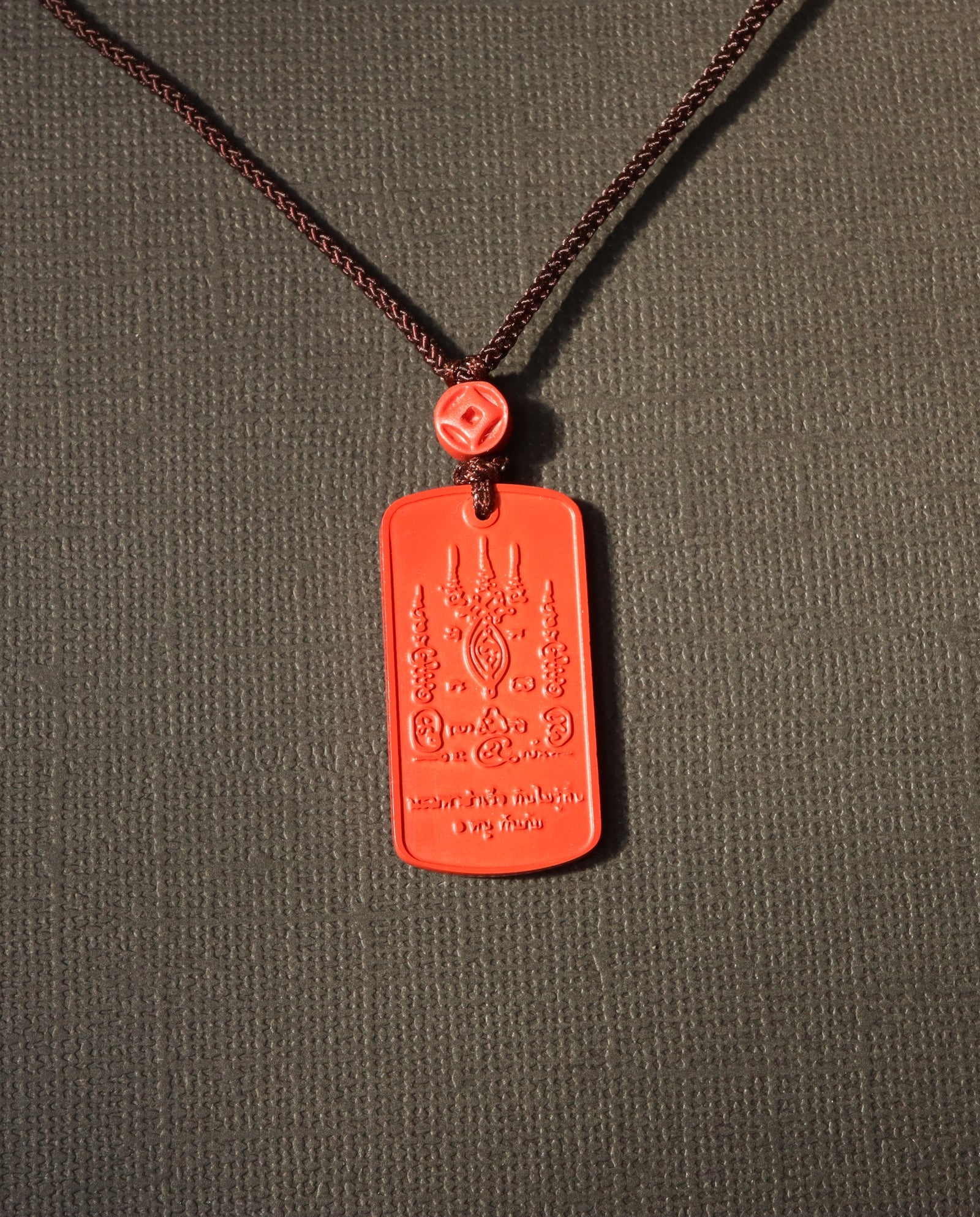 Mantra Protection Amulet cinnabar necklace on dark background