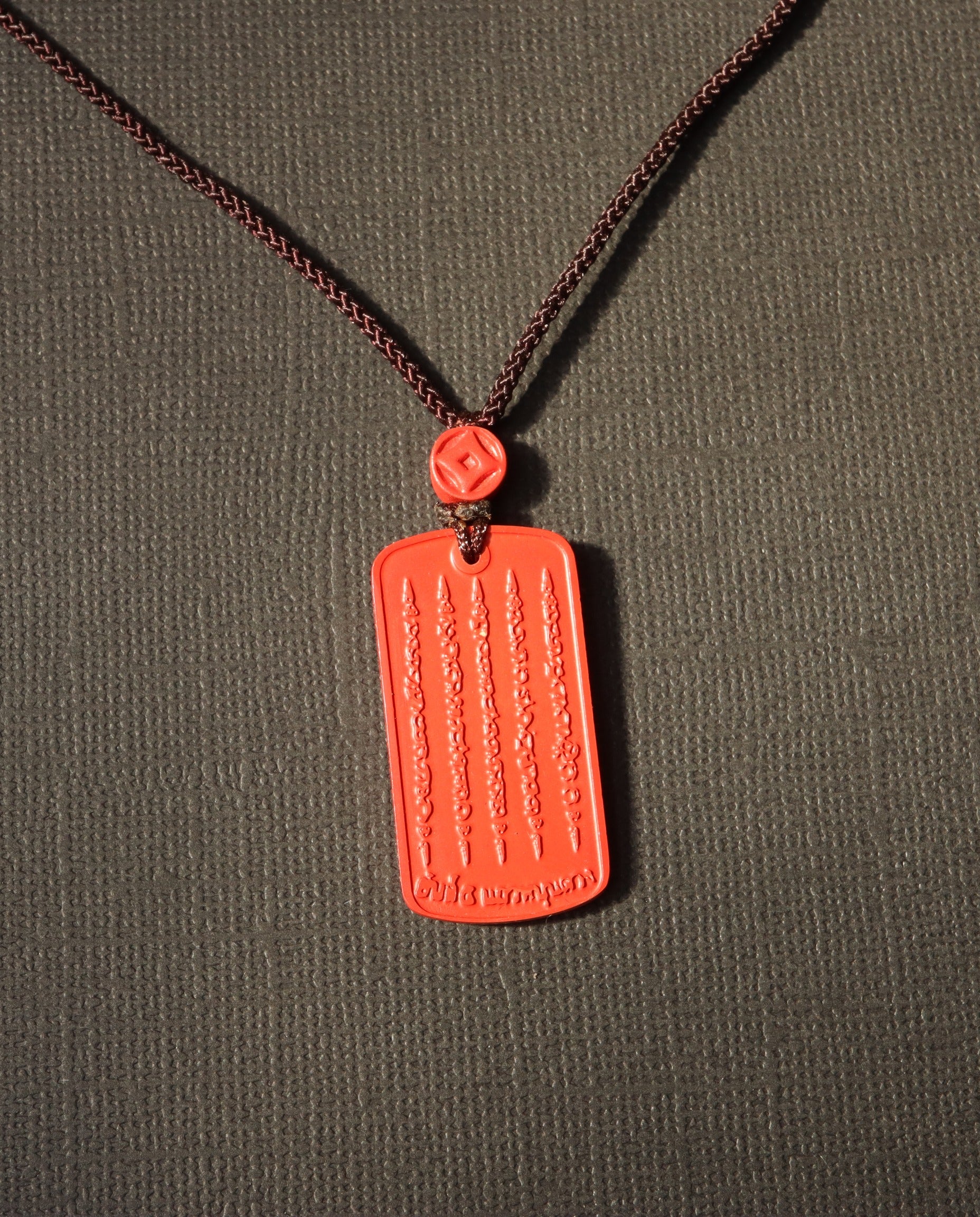 Mantra Protection Amulet cinnabar necklace on dark background