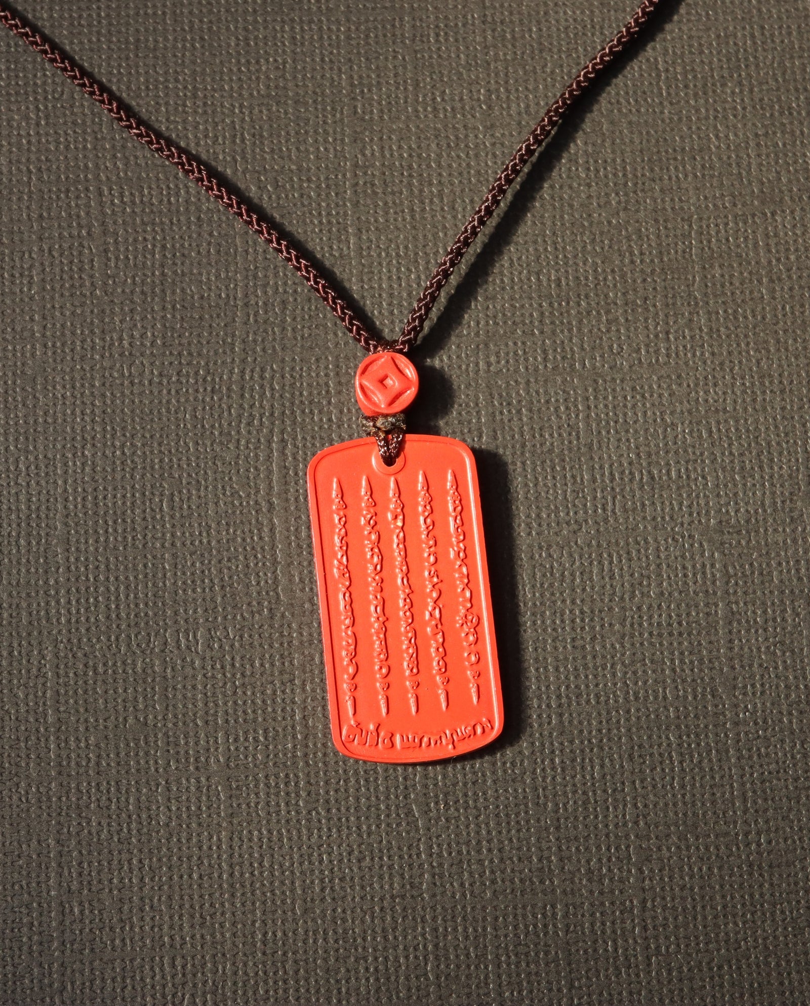 Mantra Protection Amulet cinnabar necklace on dark background