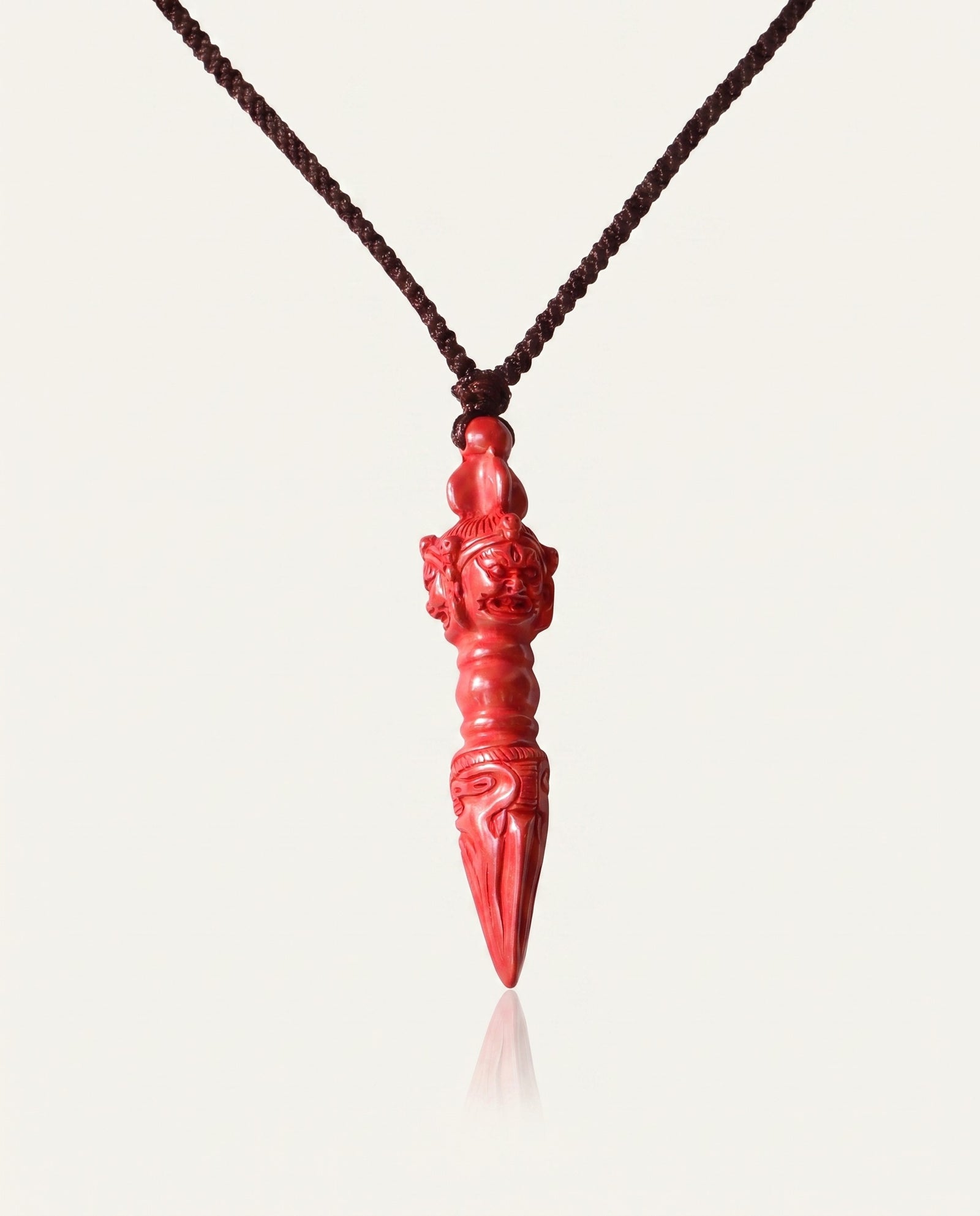Phurba cinnabar necklace on ivory studio background