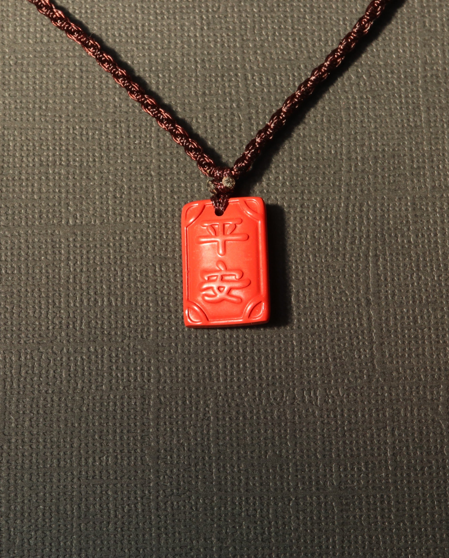 Ping An cinnabar necklace on dark background