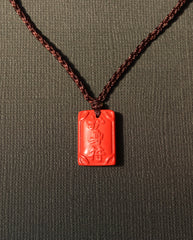 Ping An cinnabar necklace on dark background