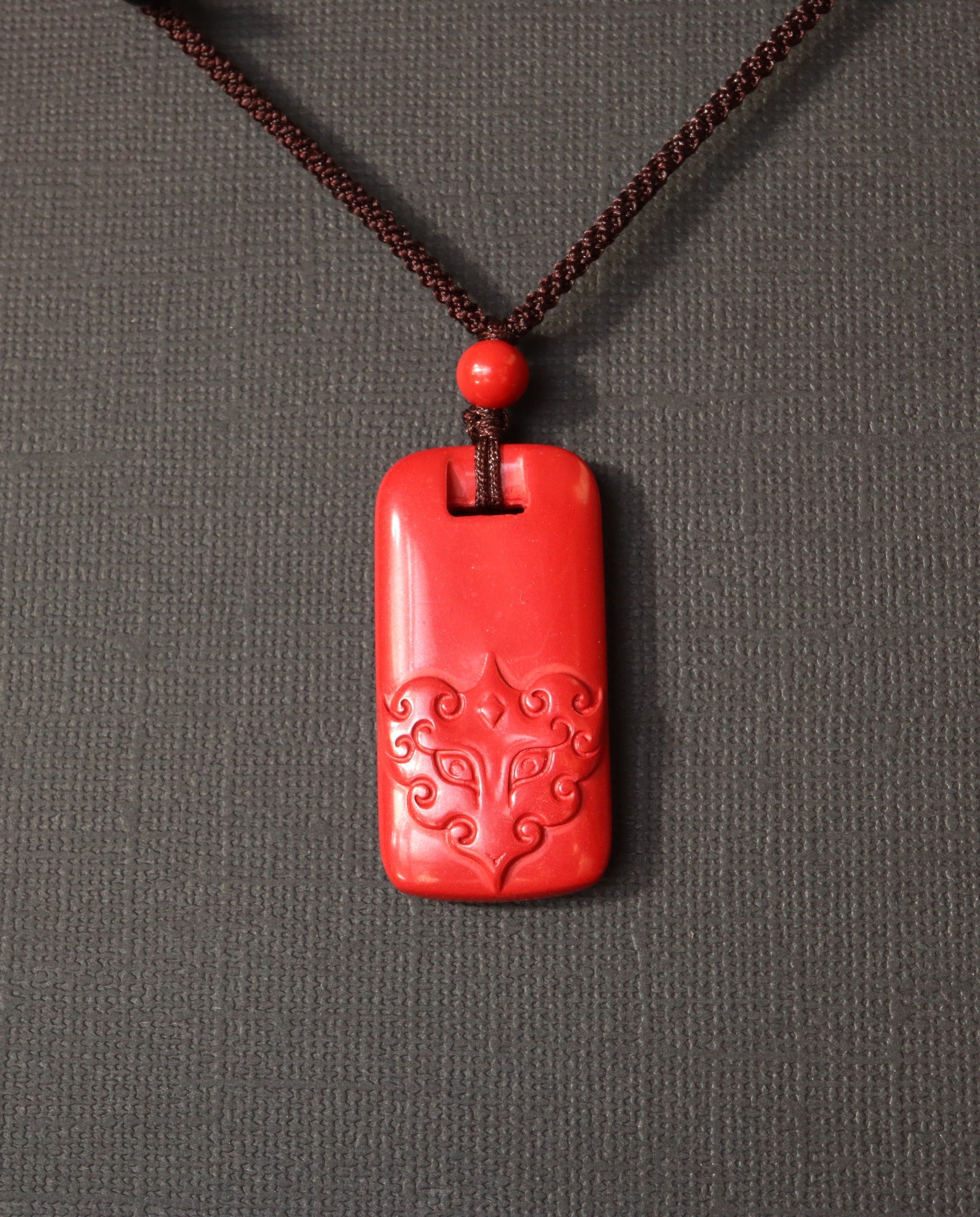 Pixiu Tag cinnabar necklace on dark background