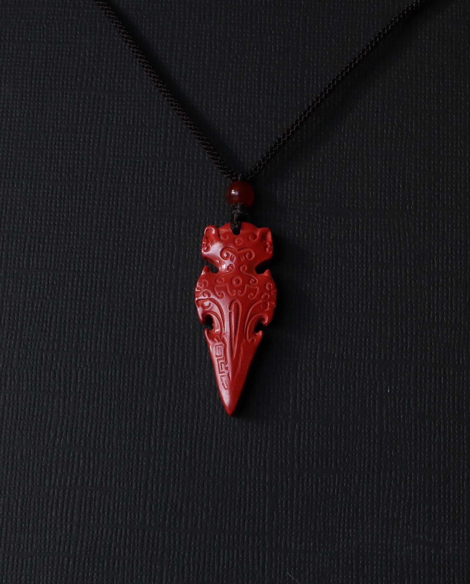 Protection Arrow cinnabar necklace on dark background