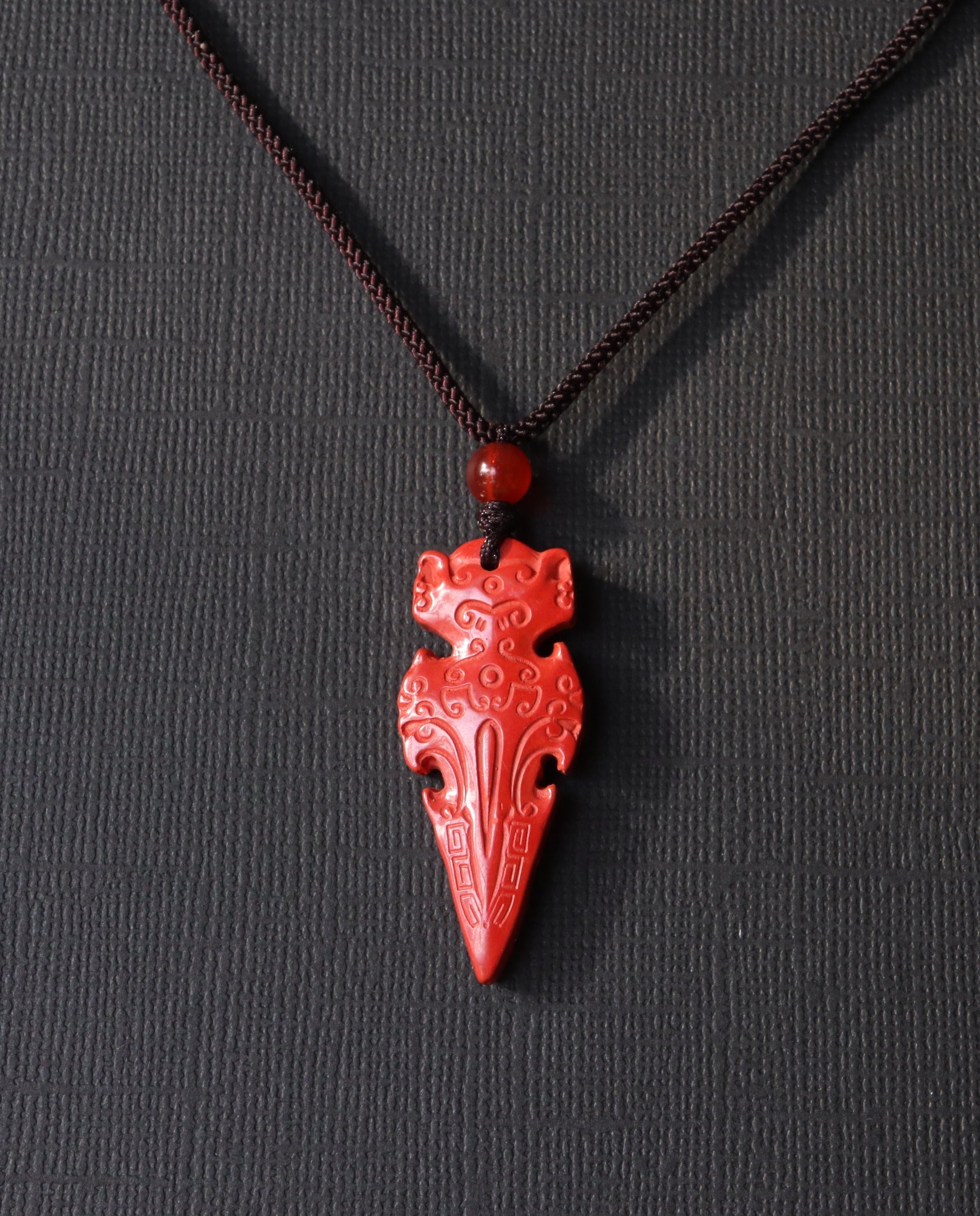 Protection Arrow cinnabar necklace on dark background