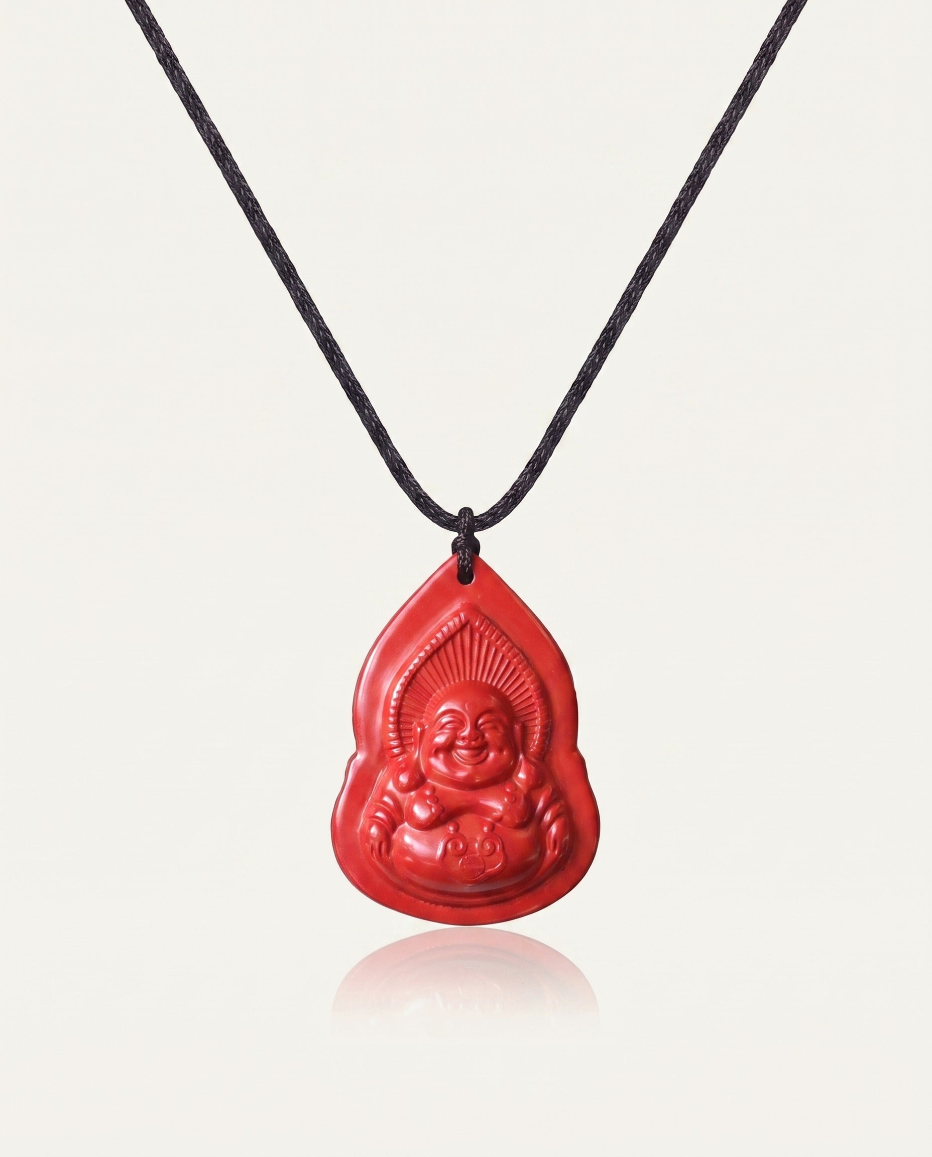 Seated Laughing Buddha cinnabar necklace on ivory studio background