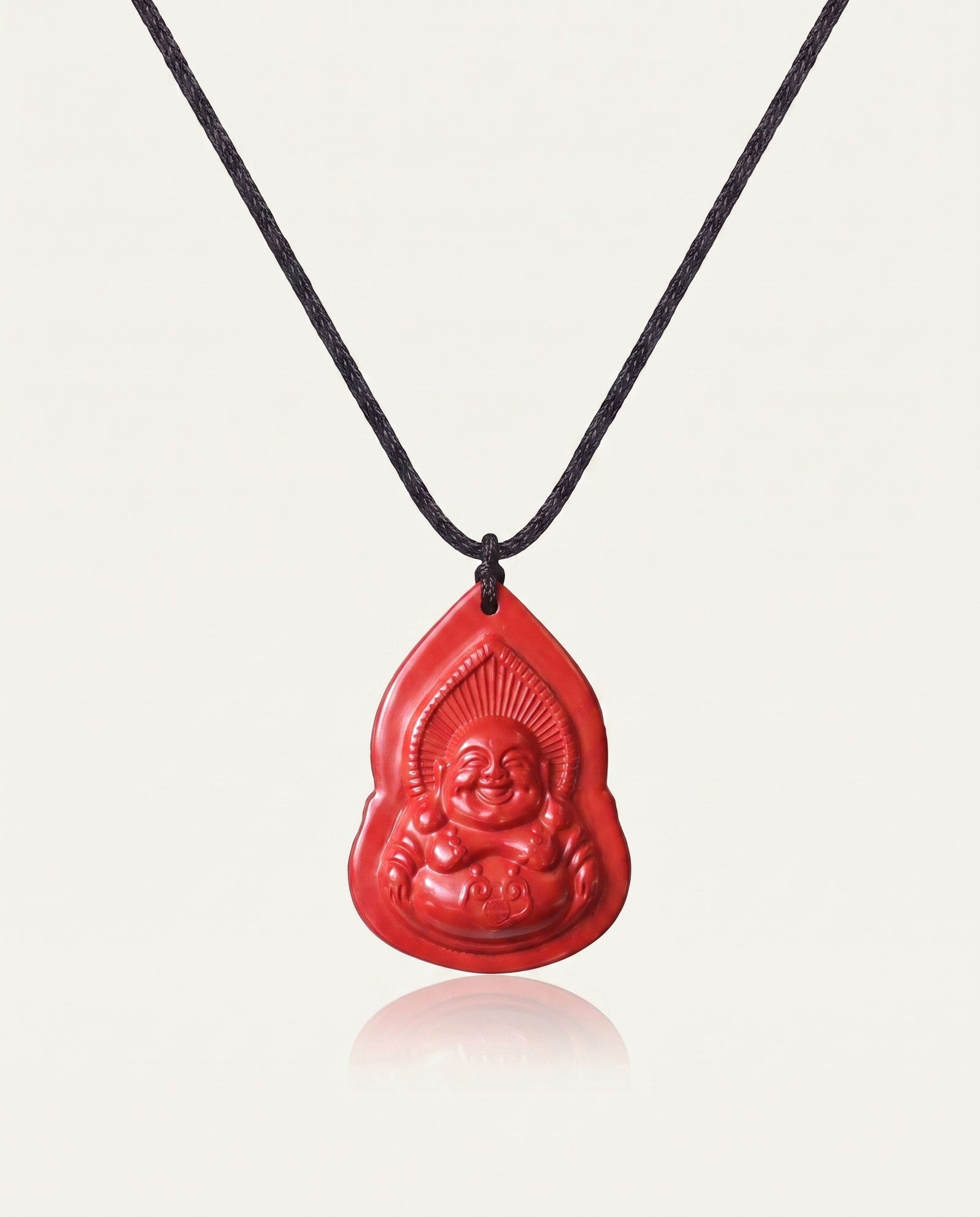 Seated Laughing Buddha cinnabar necklace on ivory studio background