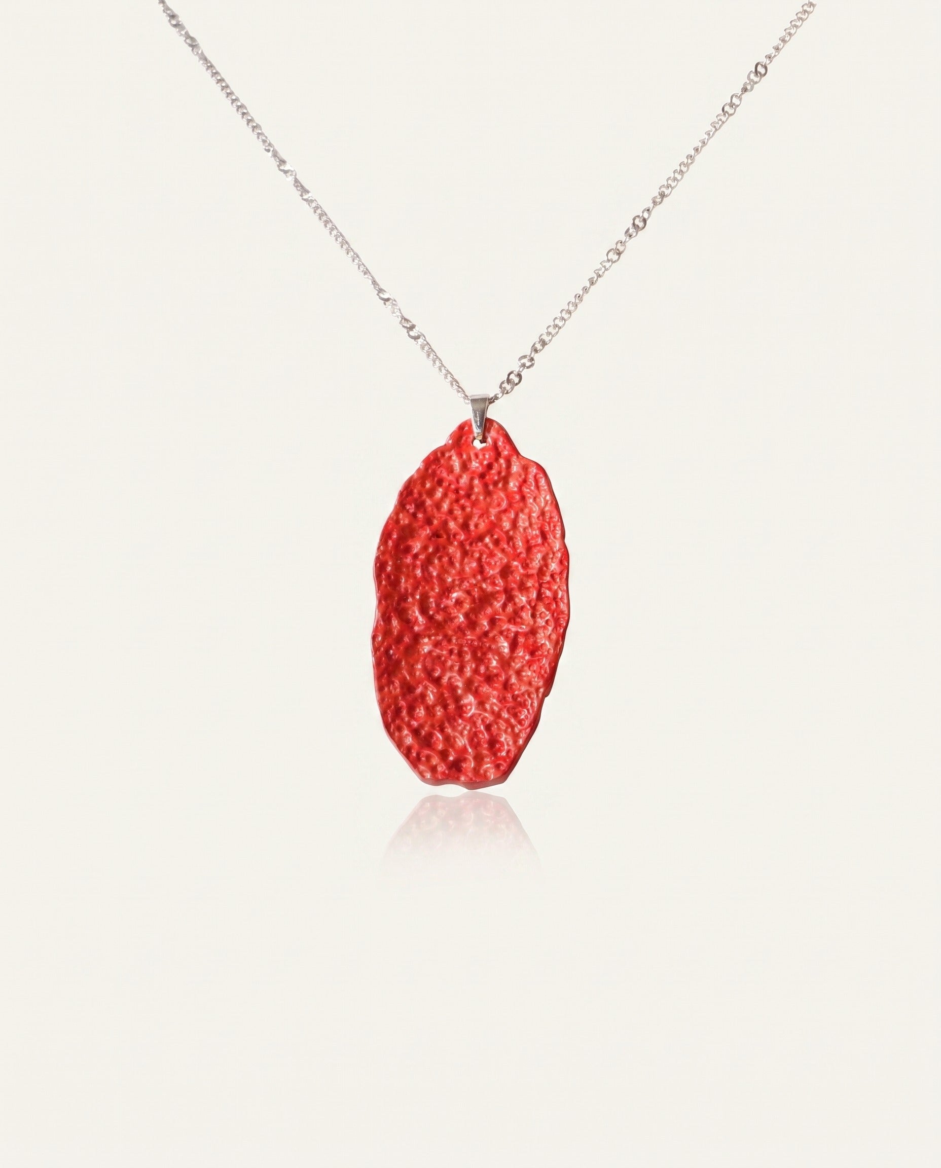 Six Character Mantra cinnabar necklace on silver chain, ivory studio background