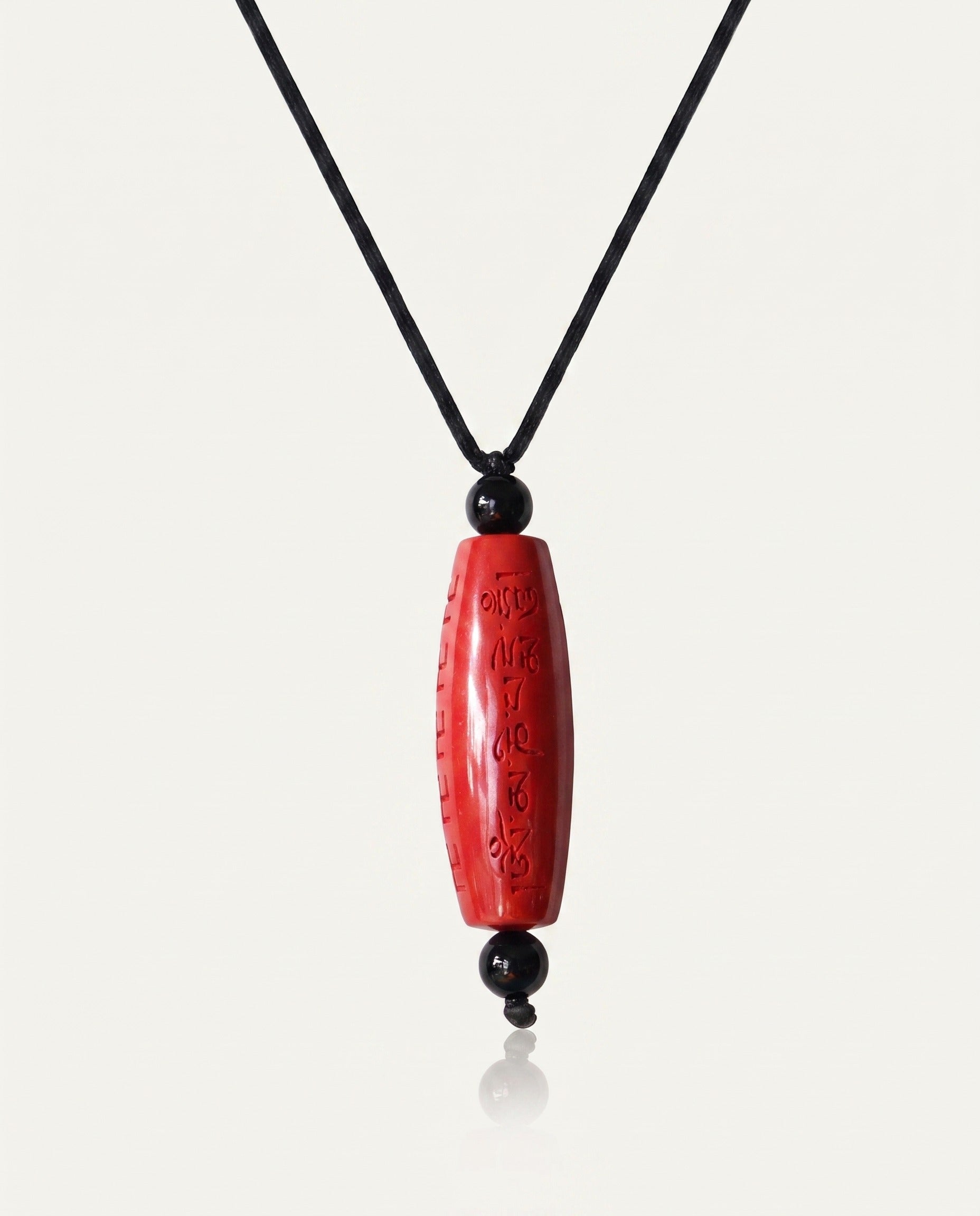 Six Character Mantra Cylinder cinnabar necklace on ivory studio background