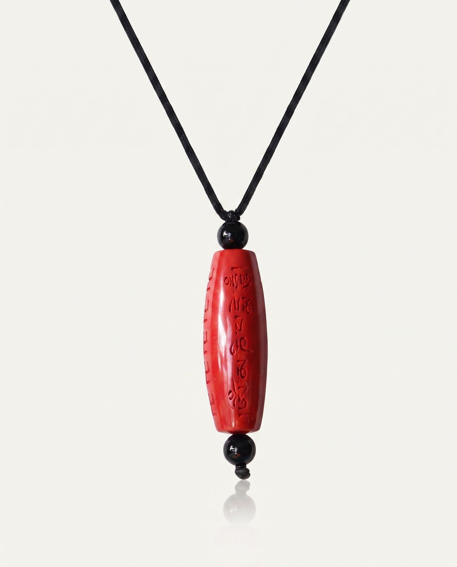 Six Character Mantra Cylinder cinnabar necklace on ivory studio background