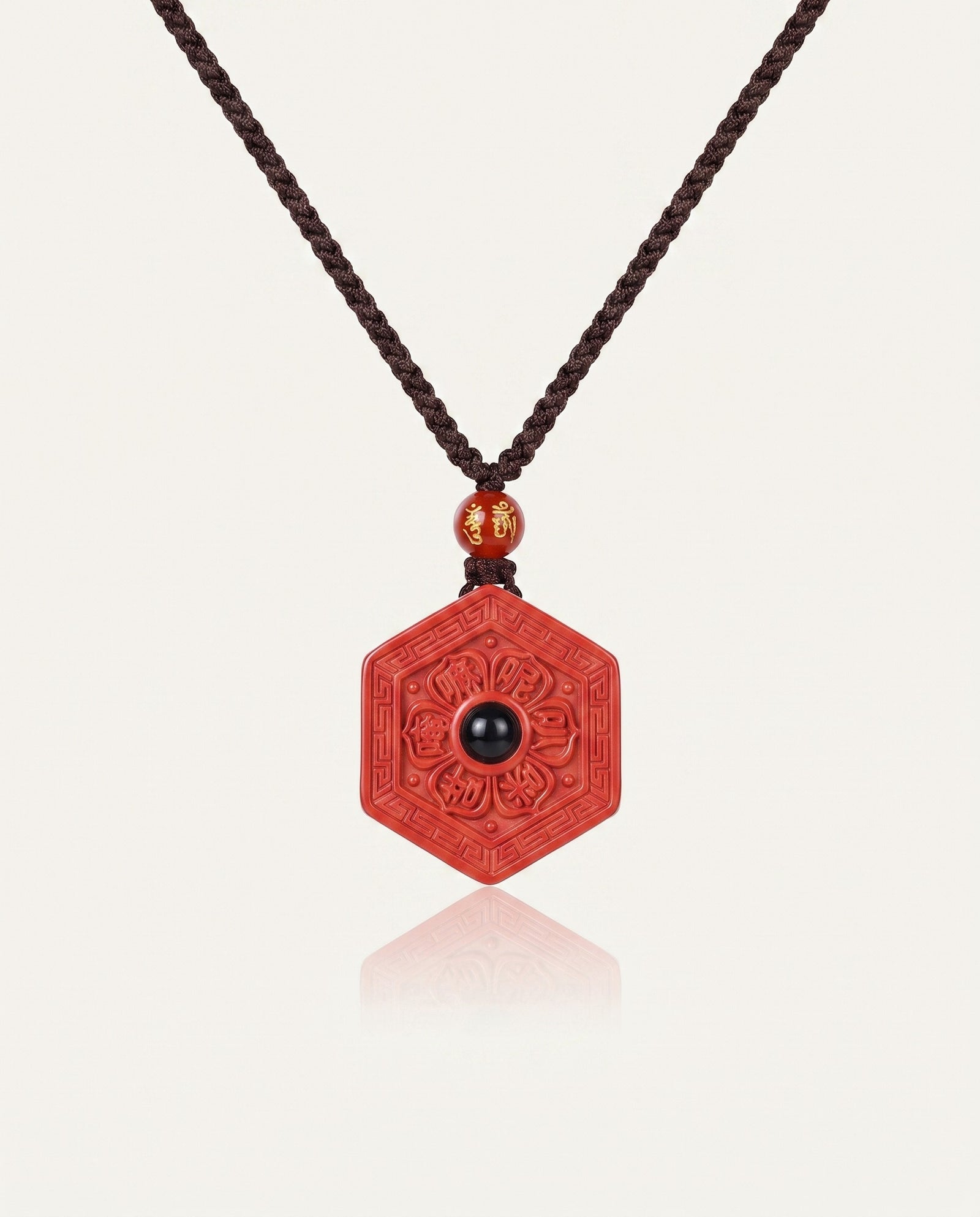 Six Character Mantra Hexagon cinnabar necklace on ivory studio background