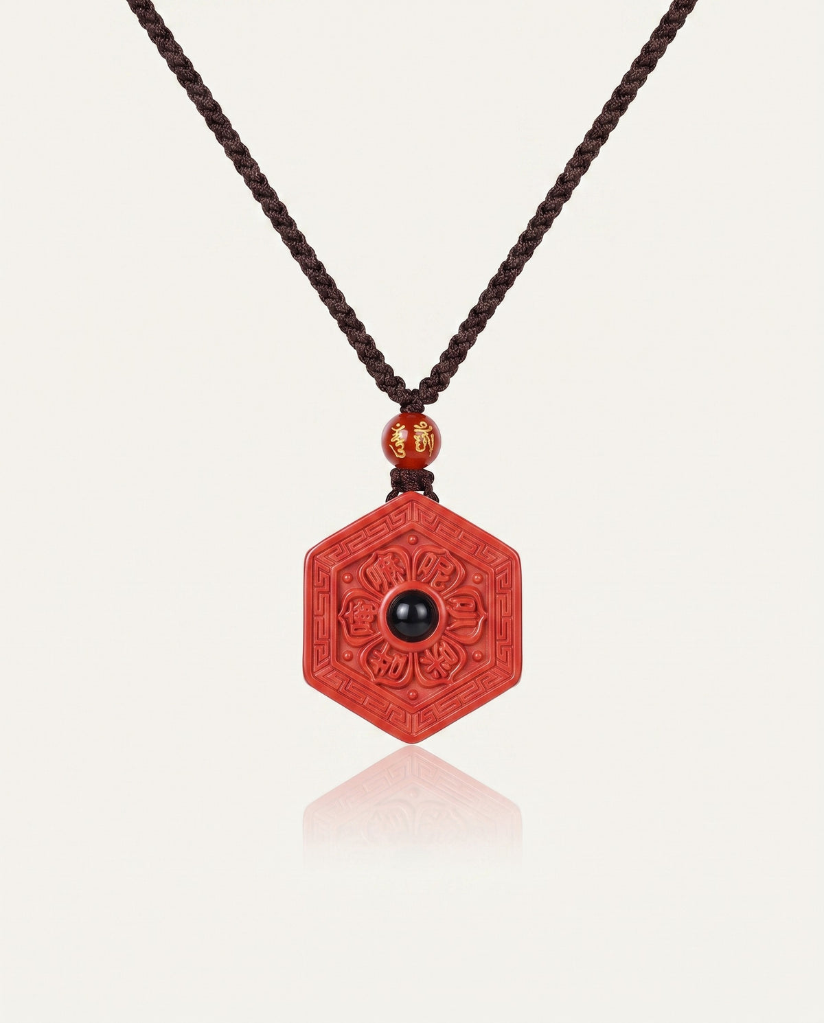 Six Character Mantra Hexagon cinnabar necklace on ivory studio background