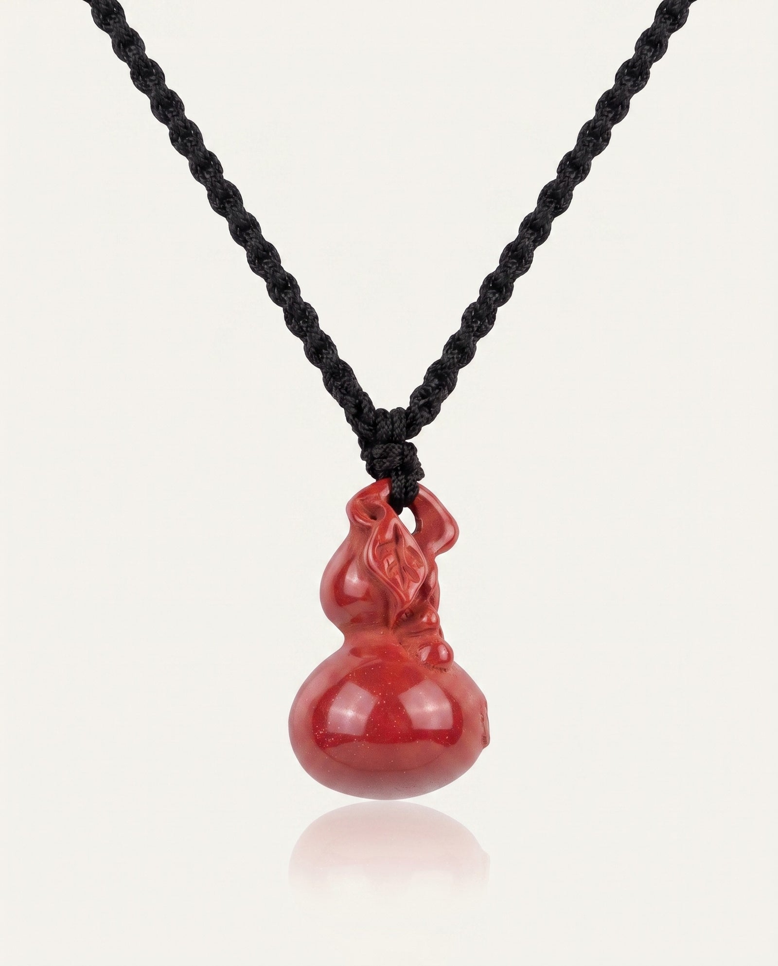 Smooth Hulu cinnabar necklace on ivory studio background