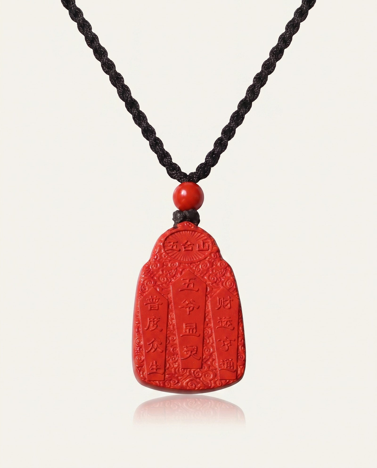 Wealth God cinnabar necklace on ivory studio background