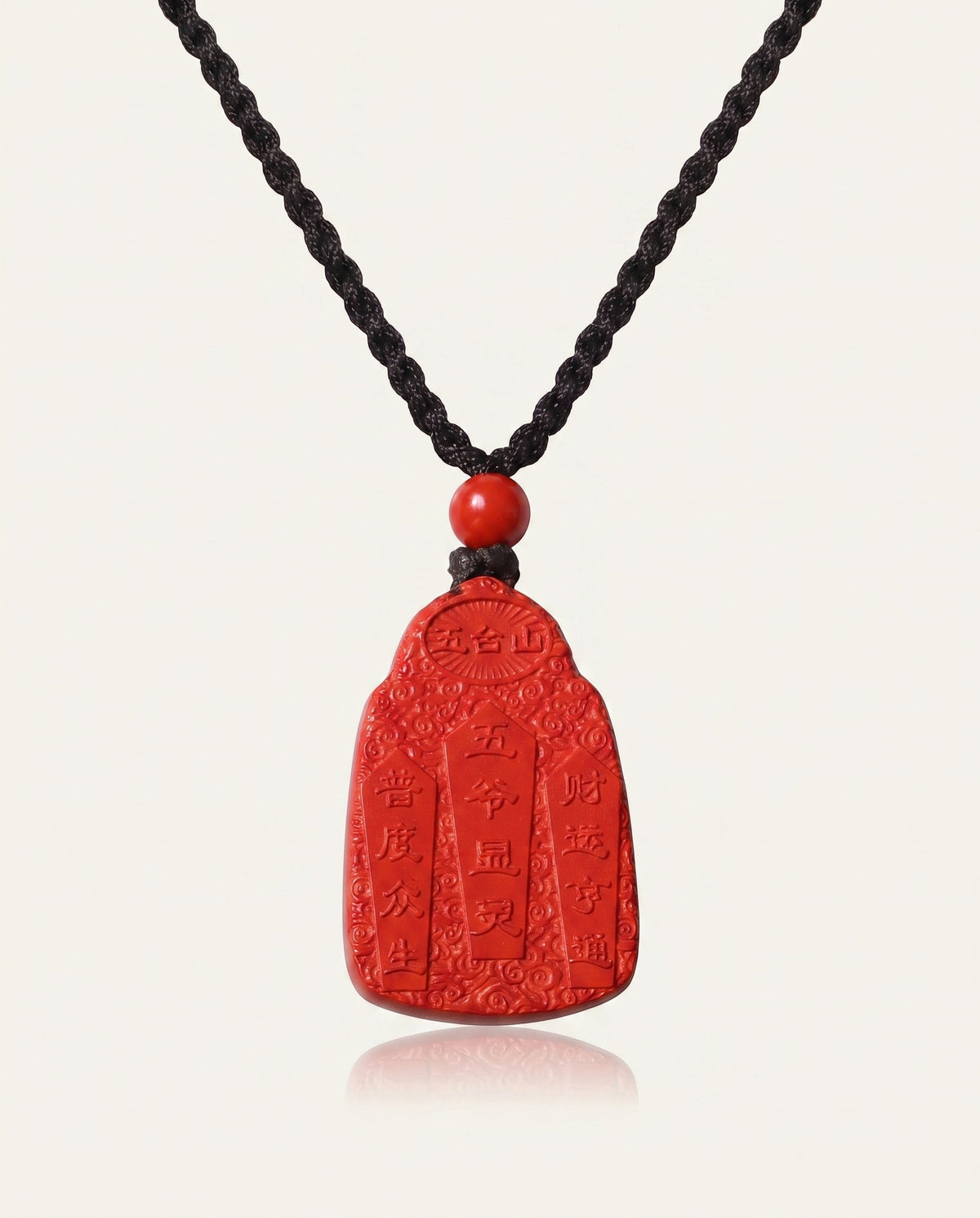 Wealth God cinnabar necklace on ivory studio background