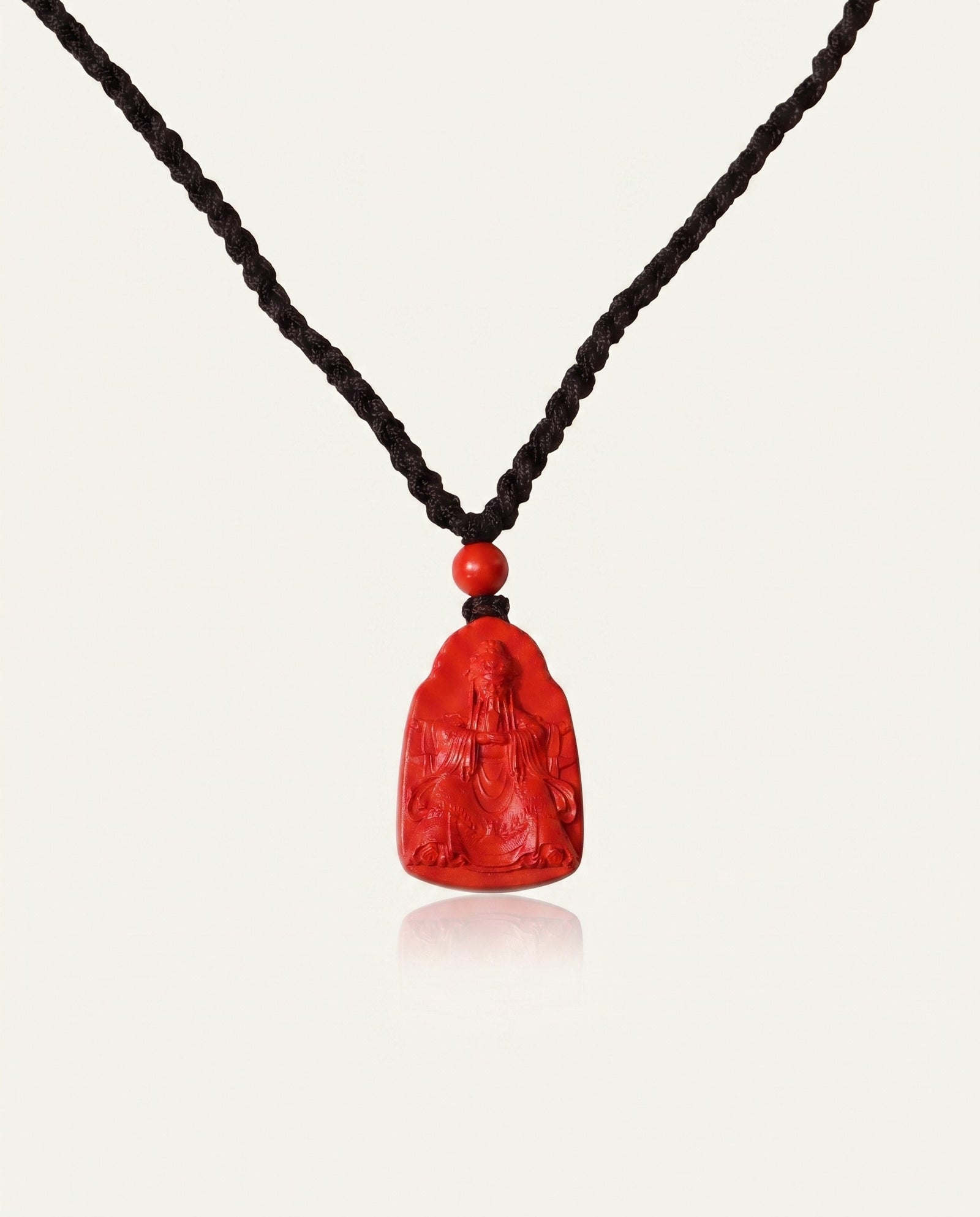 Wealth God cinnabar necklace front on ivory studio background