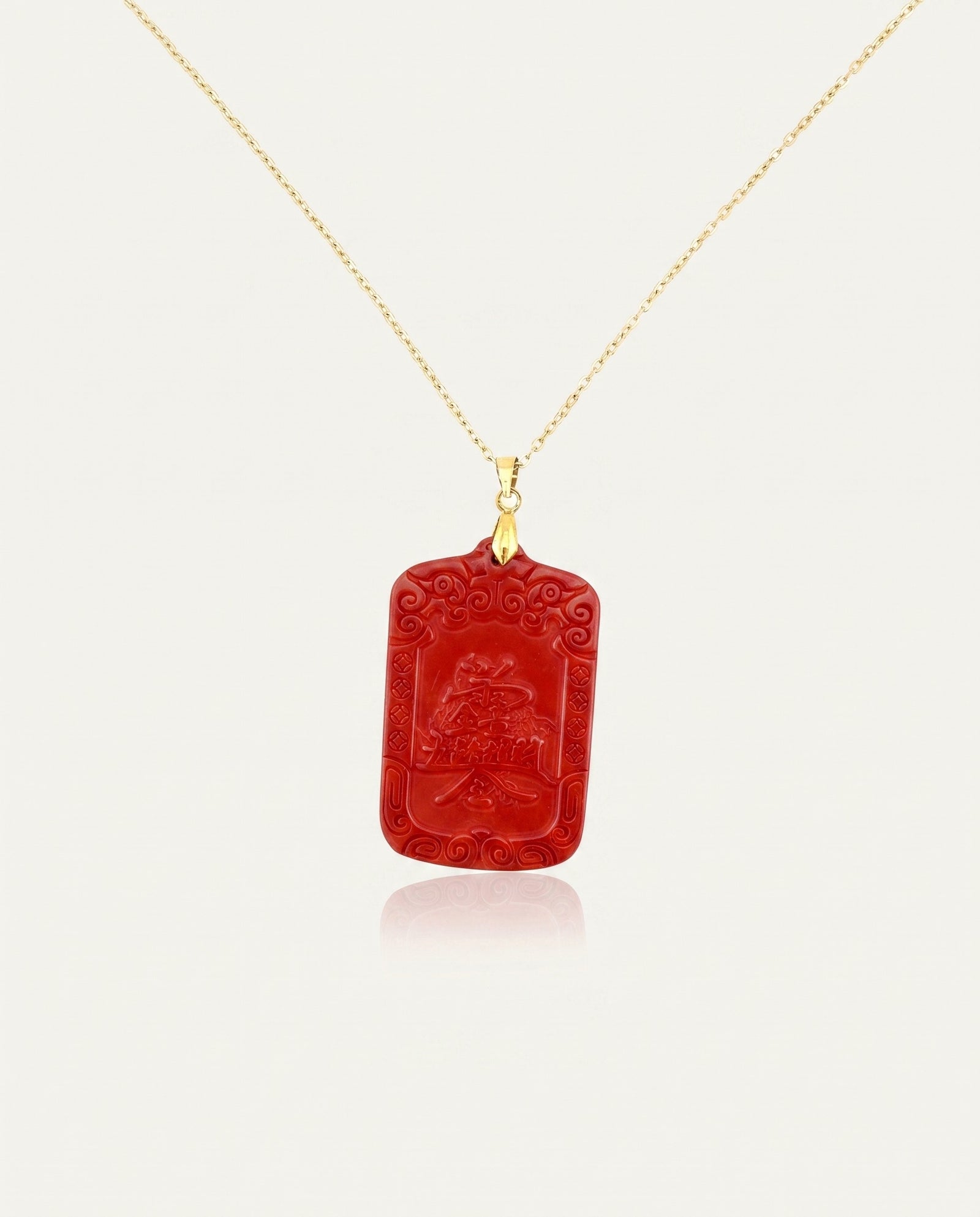 Wealth Talisman cinnabar necklace on gold chain back, ivory studio background